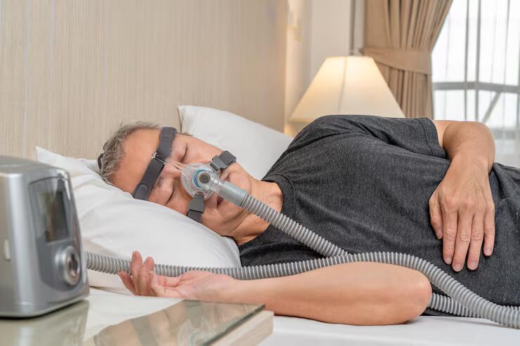 Pria paruh baya menggunakan masker dan headgear CPAP saat tidur
